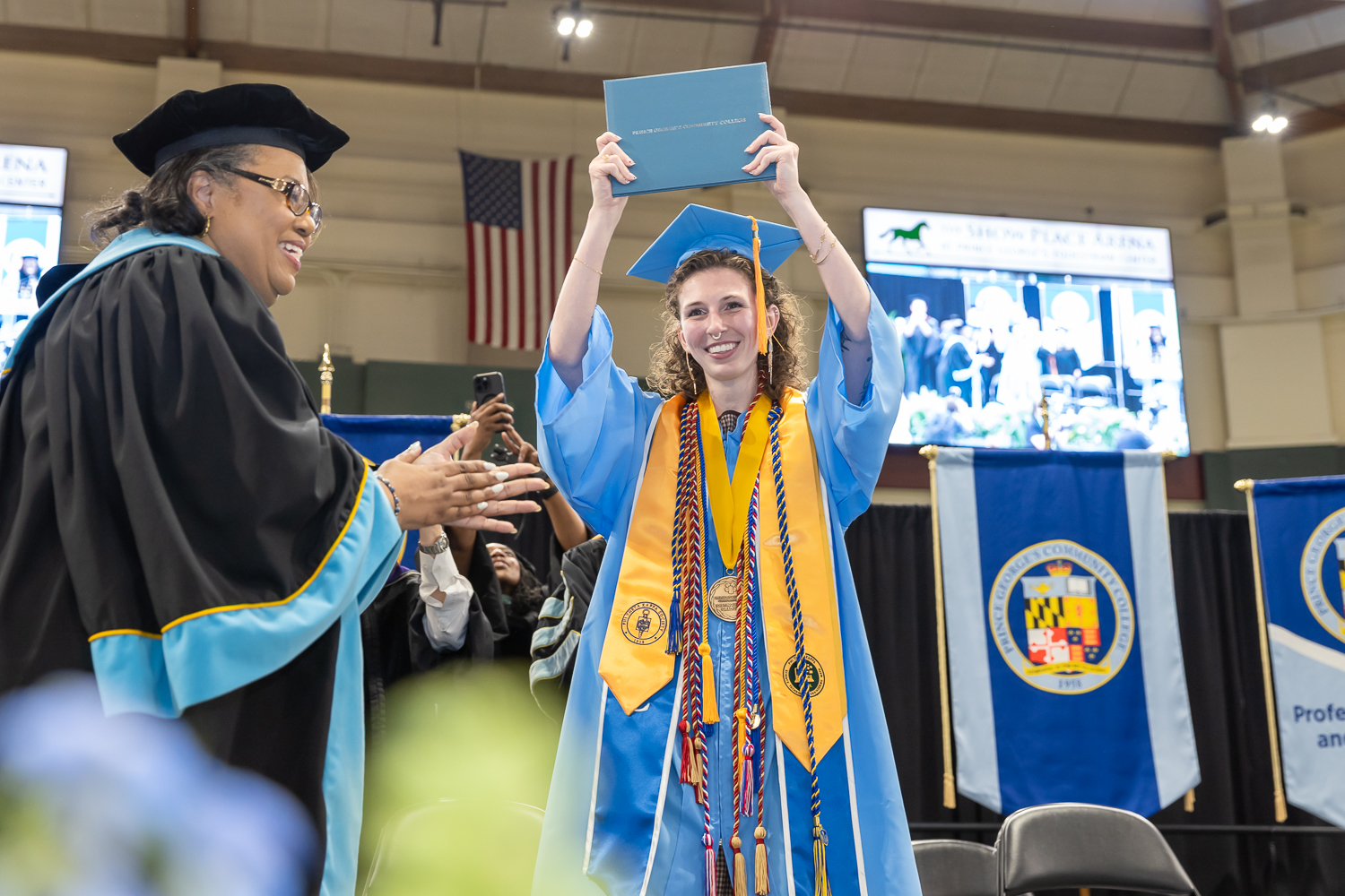 London Hudnall holding a diploma with joy and cheer.
