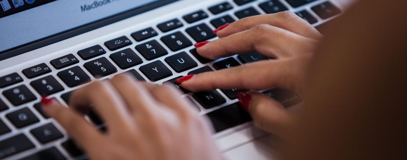 PGCC Student Typing on a MacBook