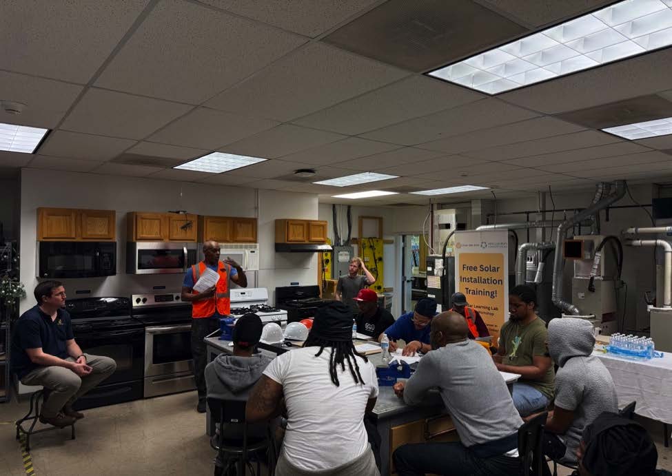 A group of students receive solar installation training inside a classroom.