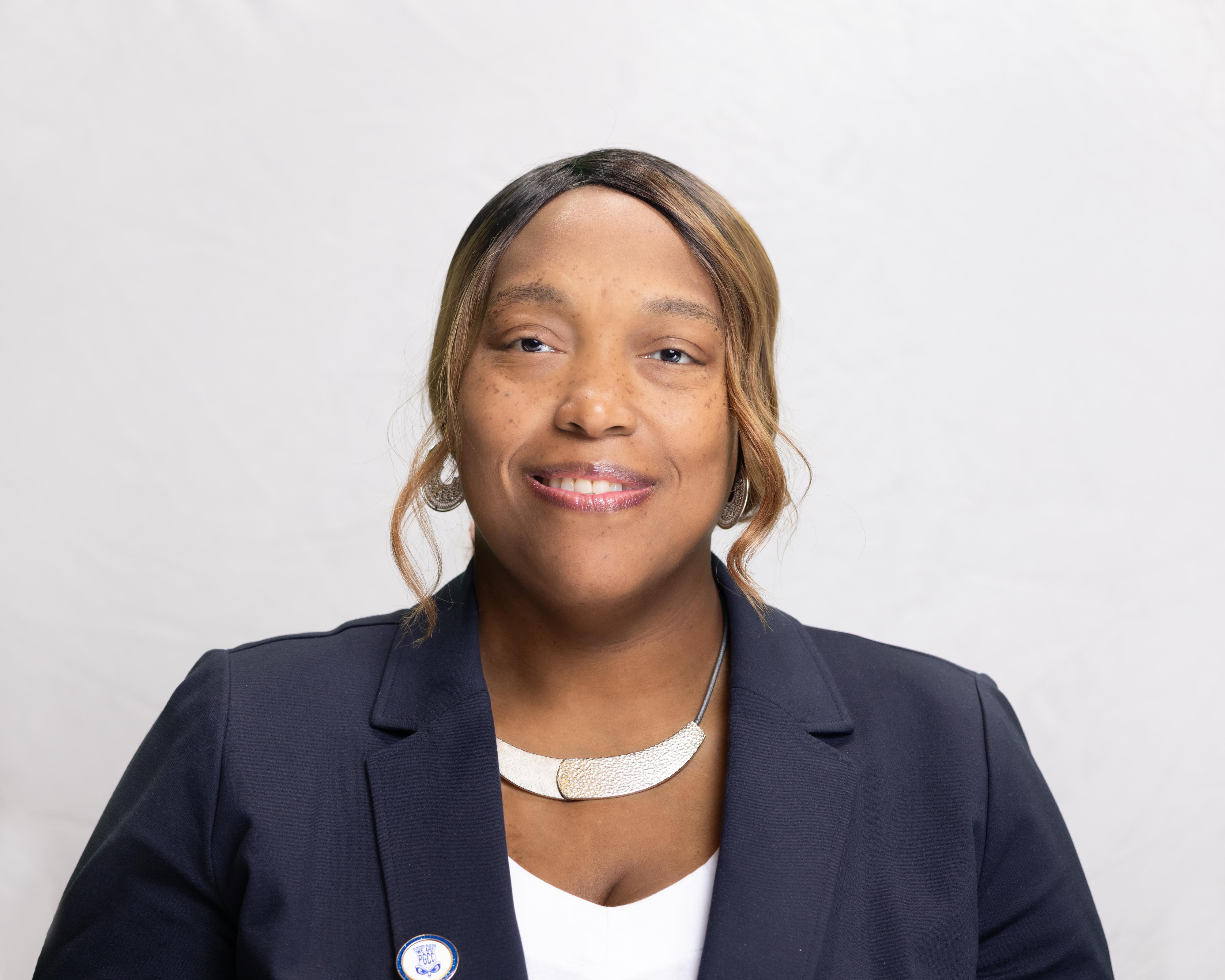 Florence Nelson smiles wearing a blue blazer.