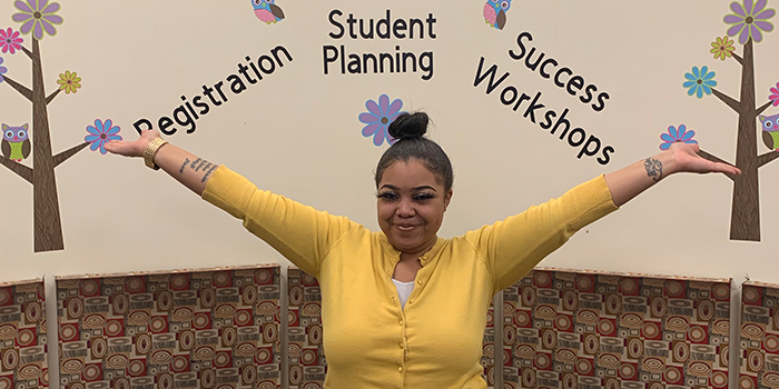 A'ja Ross, a Generation Hope Scholar standing in front of a student bulletin board