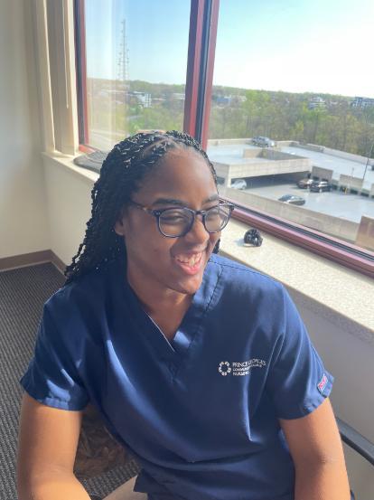 TaSharie Avery smiles wearing blue scrubs.