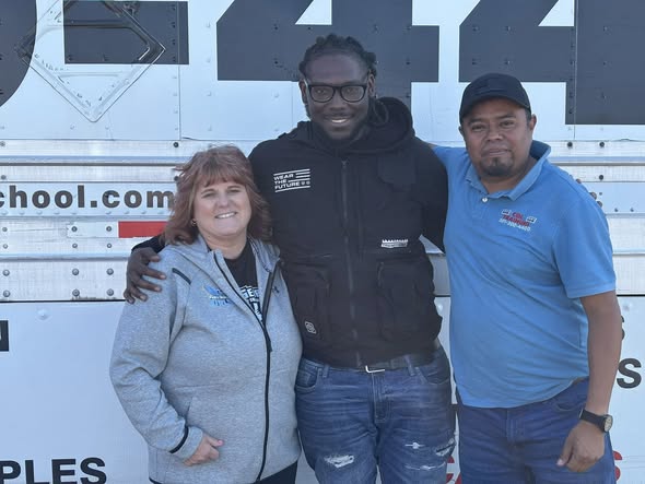 Jonathan White stands with Barbara McCreary, Transportation and Distribution program director, and instructor Juan Carlos Sanchez Solaresin front of a CDL program truck.