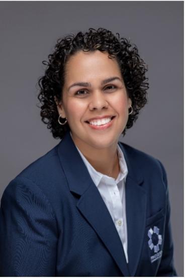 Samantha Howard smiles wearing a blue PGCC suit jacket with a white button-up shirt.