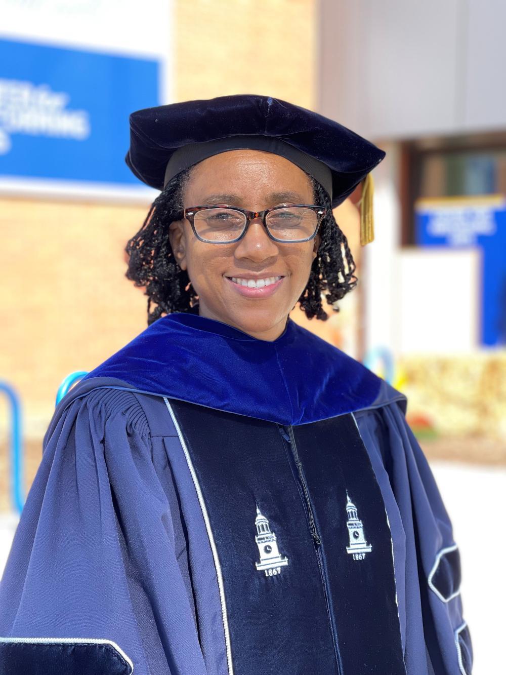 Dr. Sherelle Wiliams smiles in a cap and gown.