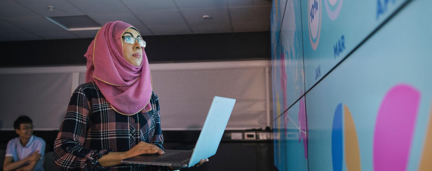 PGCC International Student Holding a Laptop in Front of Class