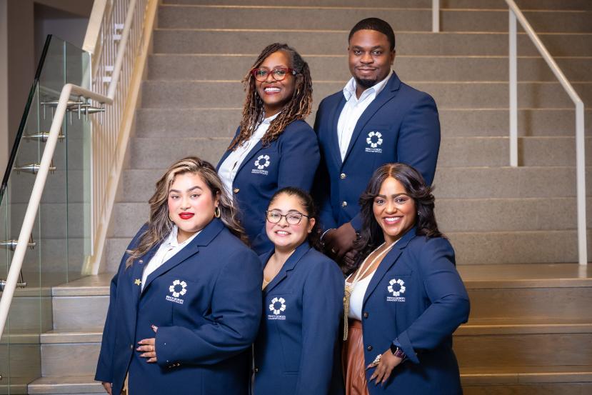 A group of five PGCC recruiters wearing navy blue blazers standing on a staircase.