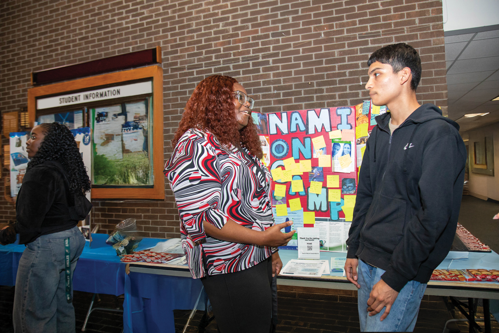 Student interacting with staff at the club fair.