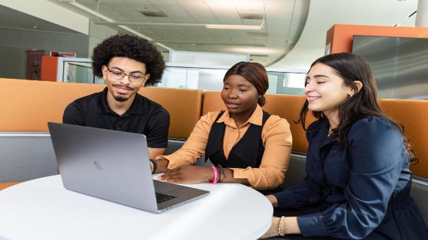 A student stands at a whiteboard labeled “Business 101,” explaining types of businesses—including LLC, sole proprietorships, partnerships, and corporations—to classmates seated nearby.
