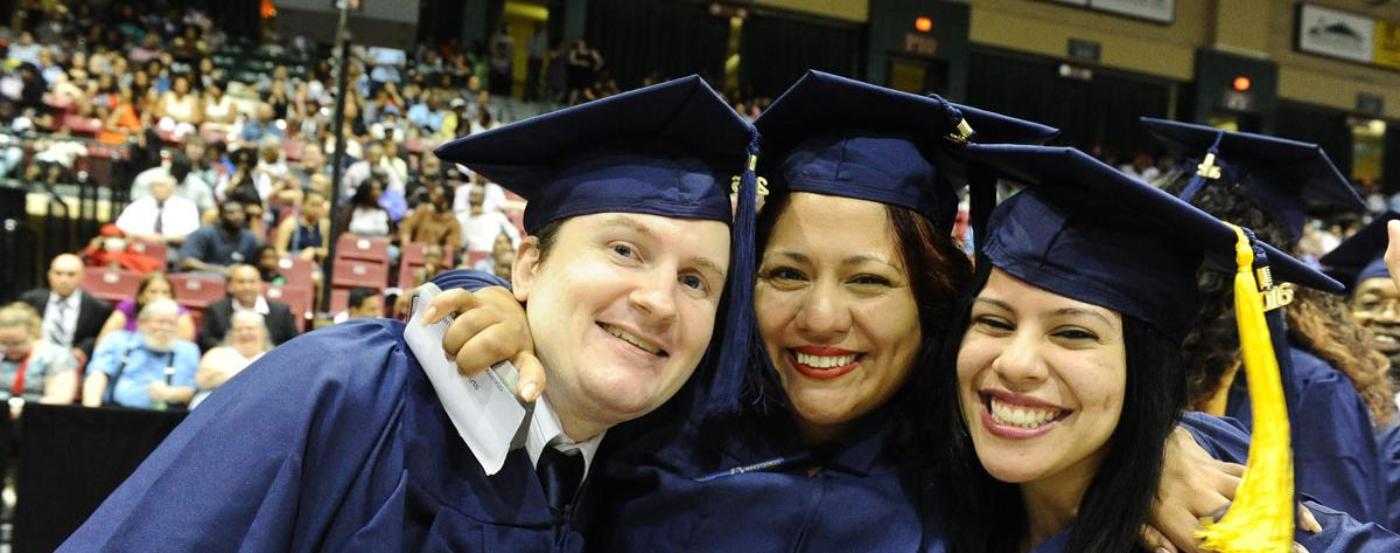 3 PGCC Students Hugging and Smiling at Commencement