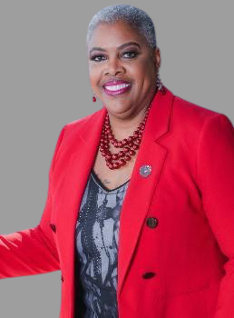 Angela McCullough smiles wearing a red blazer.