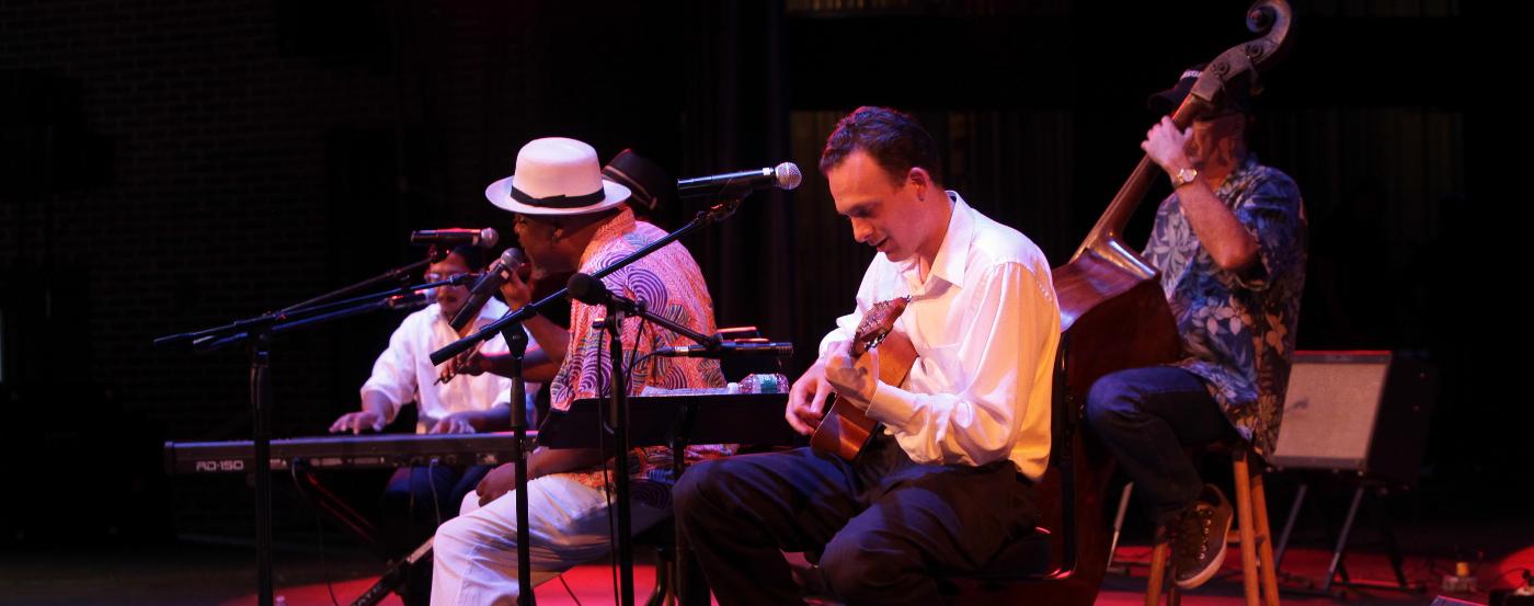 Live ensemble performing indoors on stage at a previous Bluebird Blues Festival